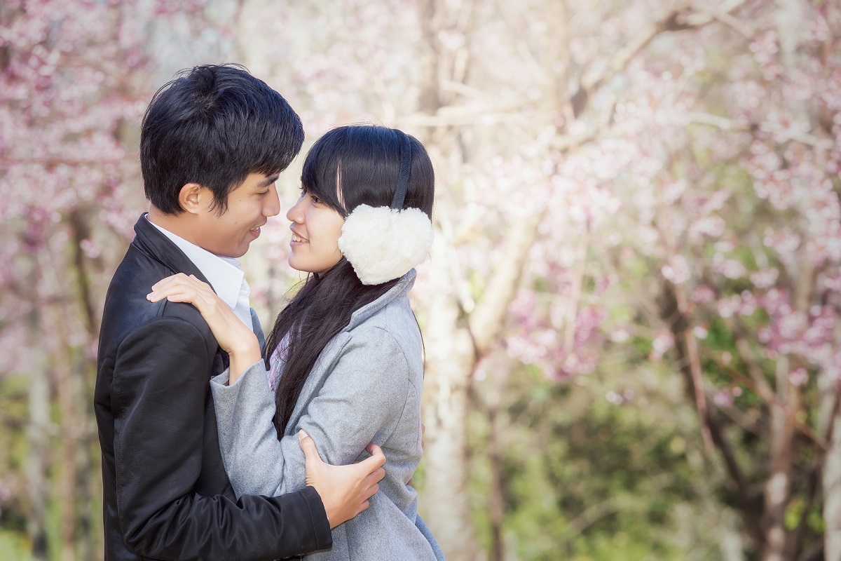 Portrait of an asian couple in park, smiling and cheerful